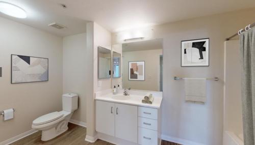a white bathroom with a toilet and a sink at Wilshire Suites in Los Angeles