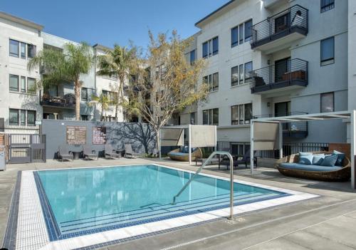 ロサンゼルスにあるWilshire Suitesのアパートメントの建物の前にスイミングプールがあります。