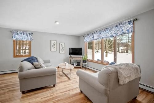 a living room with two couches and a tv at Gilford Family Retreat in Gilford