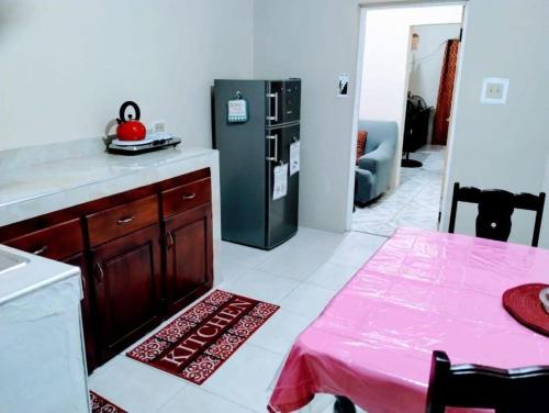 een keuken met een roze tafel en een koelkast bij Diana's Portmore Retreat in Portmore