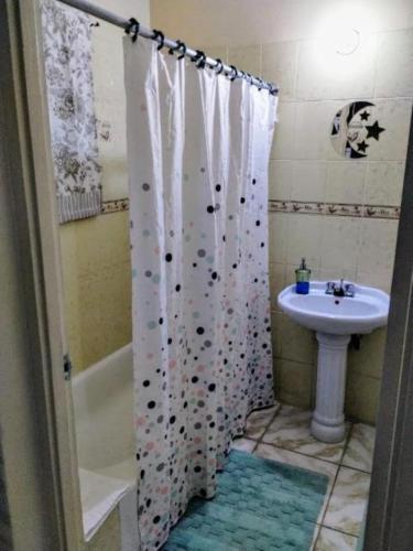 a bathroom with a shower curtain and a sink at Diana's Portmore Retreat in Portmore