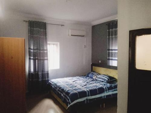- une chambre avec un lit et une couette bleue dans l'établissement Chima's Place, à Ihiala