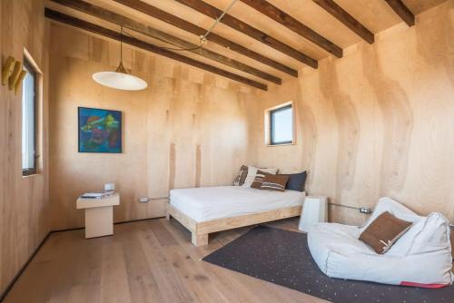 um quarto com uma cama, um sofá e uma mesa em Yucca Hut - Design Forward Oasis Near Joshua Tree em Joshua Tree