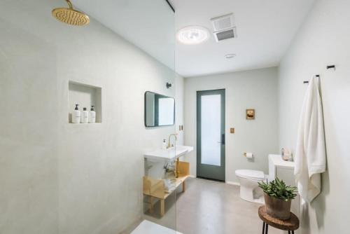 uma casa de banho branca com um lavatório e um WC em Yucca Hut - Design Forward Oasis Near Joshua Tree em Joshua Tree