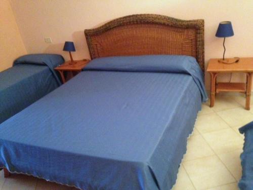 アルデーアにあるB Palaceのベッドルーム1室(青いカバーとテーブル2台付きのベッド2台付)