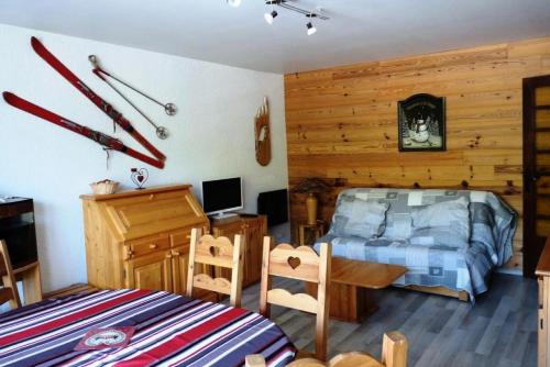 - une chambre avec un lit et un bureau avec des skis sur le mur dans l'établissement Appartement 6 pers. pied des pistes - 2 Pièces 6 Personnes MAE-8812, à Les Deux Alpes