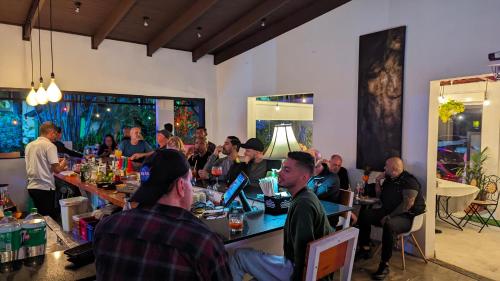 un grupo de personas sentadas en mesas en una habitación en Colours LGBTIQ Boutique Hotel & Hostal Coliving en San José