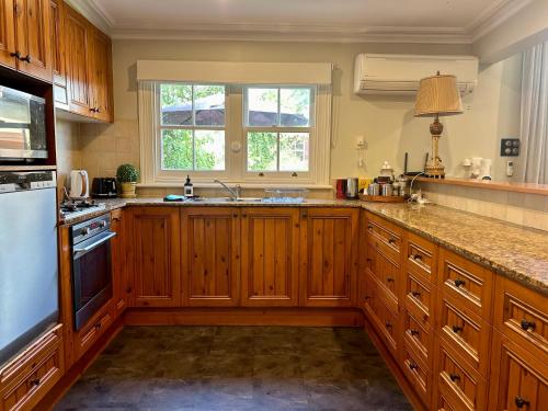 una cucina con mobili in legno e un lavello di Porters Cottage Garden ad Albury