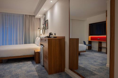 ロンドンにあるハンプトン バイ ヒルトン ロンドン ウォータールーのベッドとテレビが備わるホテルルームです。