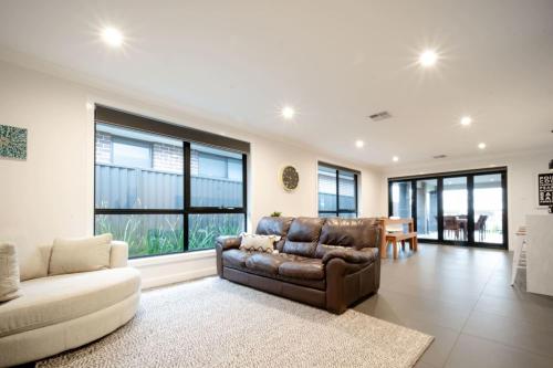a living room with a leather couch and a table at Modern Home for Large Groups or Families in Newstead