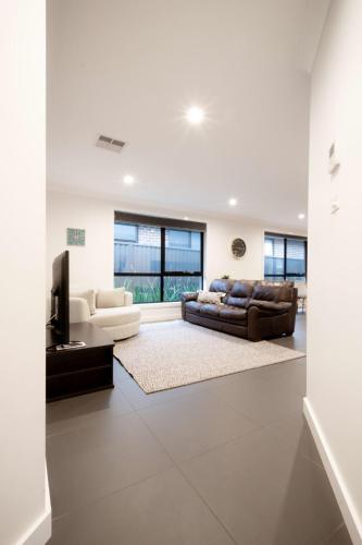 a living room with a couch and a television at Modern Home for Large Groups or Families in Newstead