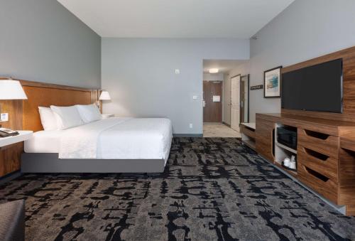 a hotel room with a bed and a flat screen tv at Hampton Inn Norfolk in Norfolk