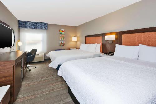 a hotel room with two beds and a flat screen tv at Hampton Inn Princeton in Princeton