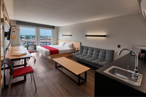 a hotel room with a king bed and a kitchen at City Express by Marriott San Luis Potosi Zona Universitaria in San Luis Potosí