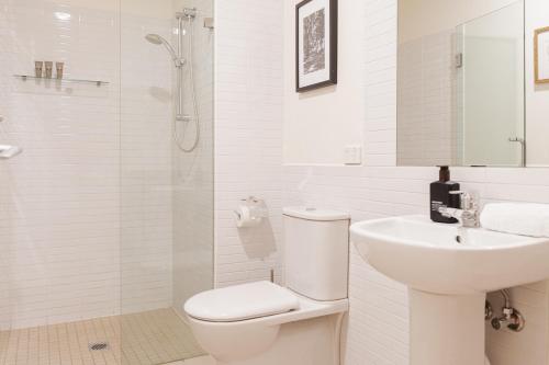 een witte badkamer met een toilet en een wastafel bij StayCentral - Merigold 21 on Collins (CBD) in Melbourne