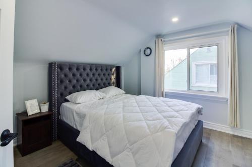 a bedroom with a large bed and a window at Beautiful 3 bedroom house, 20 minutes to Toronto downtown, free parking and Wifi in Toronto