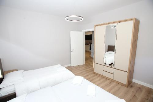 a bedroom with two beds and a mirror at The Met Apartments in Durrës