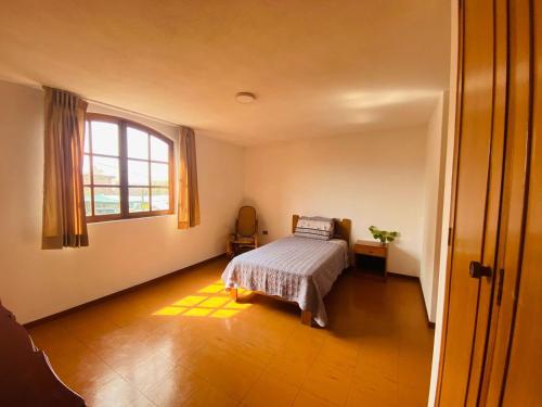 um quarto com uma cama e uma janela em Casa Zela em Yanahuara