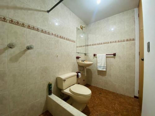 uma casa de banho com um WC, um chuveiro e um lavatório. em Casa Zela em Yanahuara