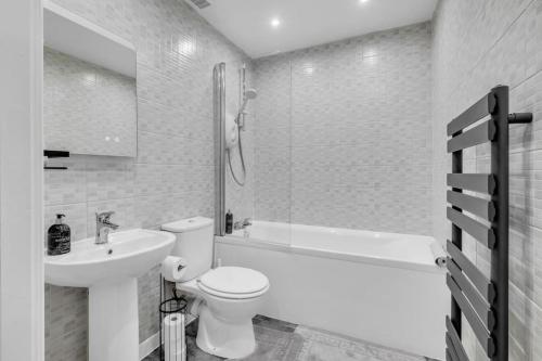 a white bathroom with a toilet and a sink at Hellena Lodge in Aberdeen