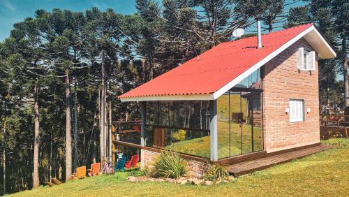a tiny house with a red roof on a hill at Cambará Ecomoradas in Cambara do Sul
