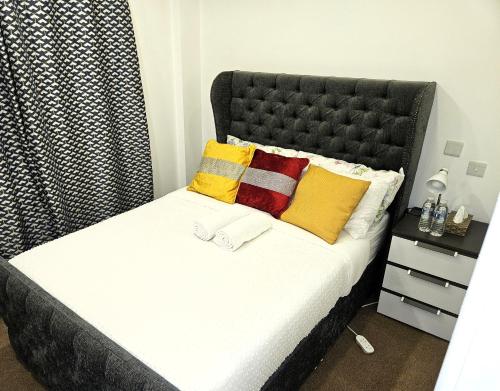 a bedroom with a bed with yellow and red pillows at LONDON SLEEPHOUSE in London