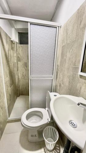 a bathroom with a toilet and a sink at Hotel Balcon de Oro Curumani in Curumaní