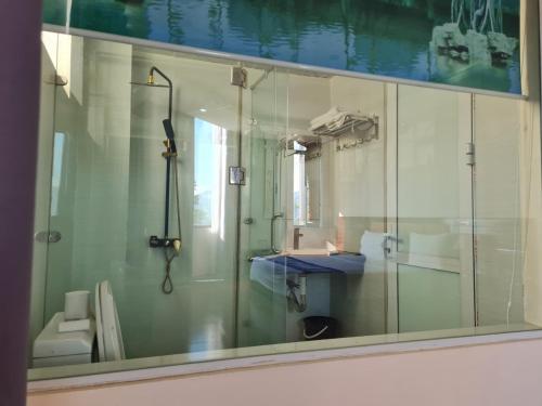 ein Bad mit einer Dusche und einem Glasfenster in der Unterkunft Minh Sơn Hotel in Ta Lan Than