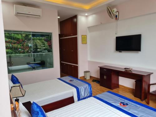 a hotel room with two beds and a television at Minh Sơn HOTEL in Ta Lan Than