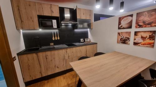 een keuken met houten kasten en een houten tafel bij Studio Apartment Ariston in centro a Cortina in Cortina dʼAmpezzo