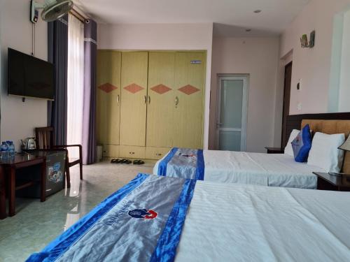 a hotel room with two beds and a television at Minh Sơn HOTEL in Ta Lan Than