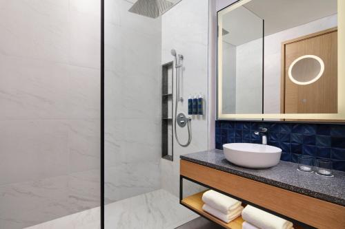 y baño con lavabo y ducha. en Four Points by Sheraton Bintan, Lagoi Bay en Lagoi