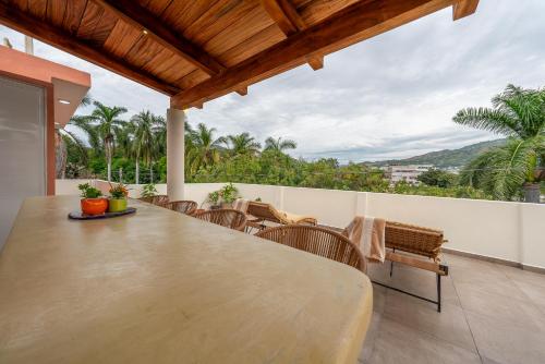 a patio with a table and chairs on a balcony at Villas EVA - Zihuatanejo in Zihuatanejo