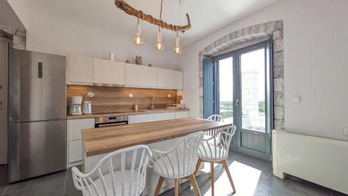 uma cozinha com um balcão com cadeiras e um frigorífico em Sabaton Apartment em Leonidio