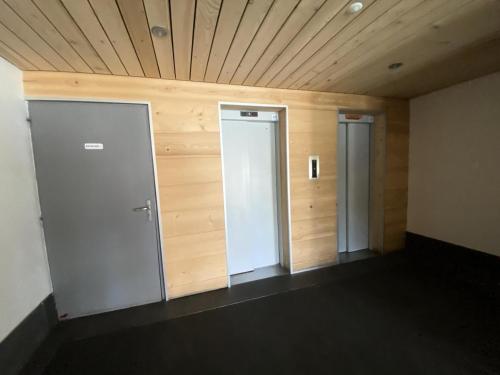 une chambre vide avec deux portes et des murs en bois dans l'établissement Résidence Hauts De La Vanoise - Studio pour 2 Personnes 24, à Val Thorens