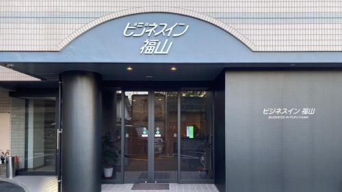 a building with a sign on the front of it at Business Inn Fukuyama in Fukuyama