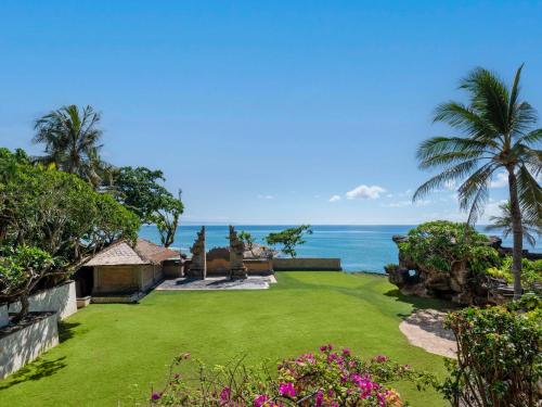 un jardín con el océano en el fondo en Hilton Bali Resort en Nusa Dua