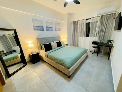 - une chambre avec un lit, un miroir et un bureau dans l'établissement Apartamento en bella vista, à Saint-Domingue