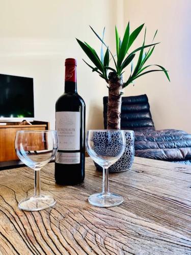 une bouteille de vin et deux verres à vin sur une table dans l'établissement Suite Eugenie Hyper center 3 rooms 2 bedrooms, à Nice