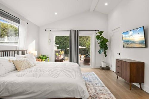 um quarto com uma cama branca e uma grande janela em Modern Spacious Romantic LA Home Gated Yard HotTub em Los Angeles