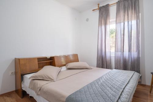 a bedroom with a large bed with a window at Seaside secluded apartments Cove Vela Borova, Korcula - 15062 in Prizba