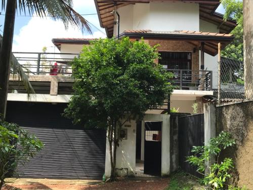 a house with a tree in front of it at Saman Villa in Kadawata