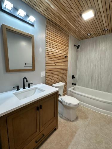 La salle de bains est pourvue d'un lavabo, de toilettes et d'une baignoire. dans l'établissement North Coast Place, à Marquette