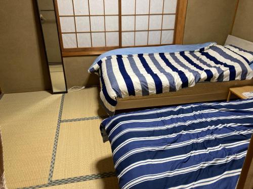 two beds sitting next to each other in a room at Guest House Hinode in Takayama