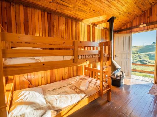 a bedroom with two bunk beds in a cabin at Costão do Cambará Pousada Fazenda in Cambara do Sul