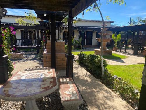 a patio with a table and a bench in a yard at Estancita Elena in Valle de Guadalupe