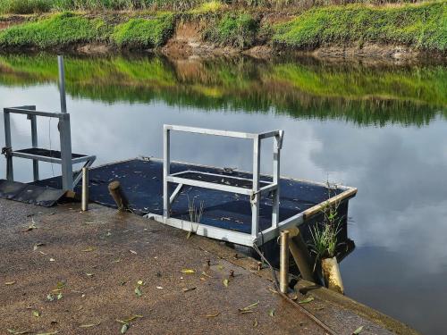 two chairs sitting on a dock in the water at Riverview Homestead 8pp - Bring The Boat! in Dungay