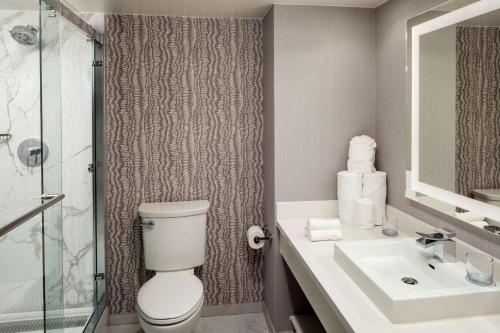 a bathroom with a toilet and a sink and a shower at Whitney Peak Hotel Reno, Tapestry Collection by Hilton in Reno