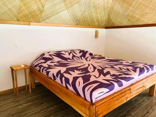 - un lit dans un coin de chambre dans l'établissement Bungalow Tiarii, avec accès direct à une plage privée, à Tevaitoa