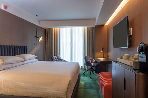 a hotel room with a bed and a flat screen tv at Doubletree By Hilton Lima San Isidro in Lima